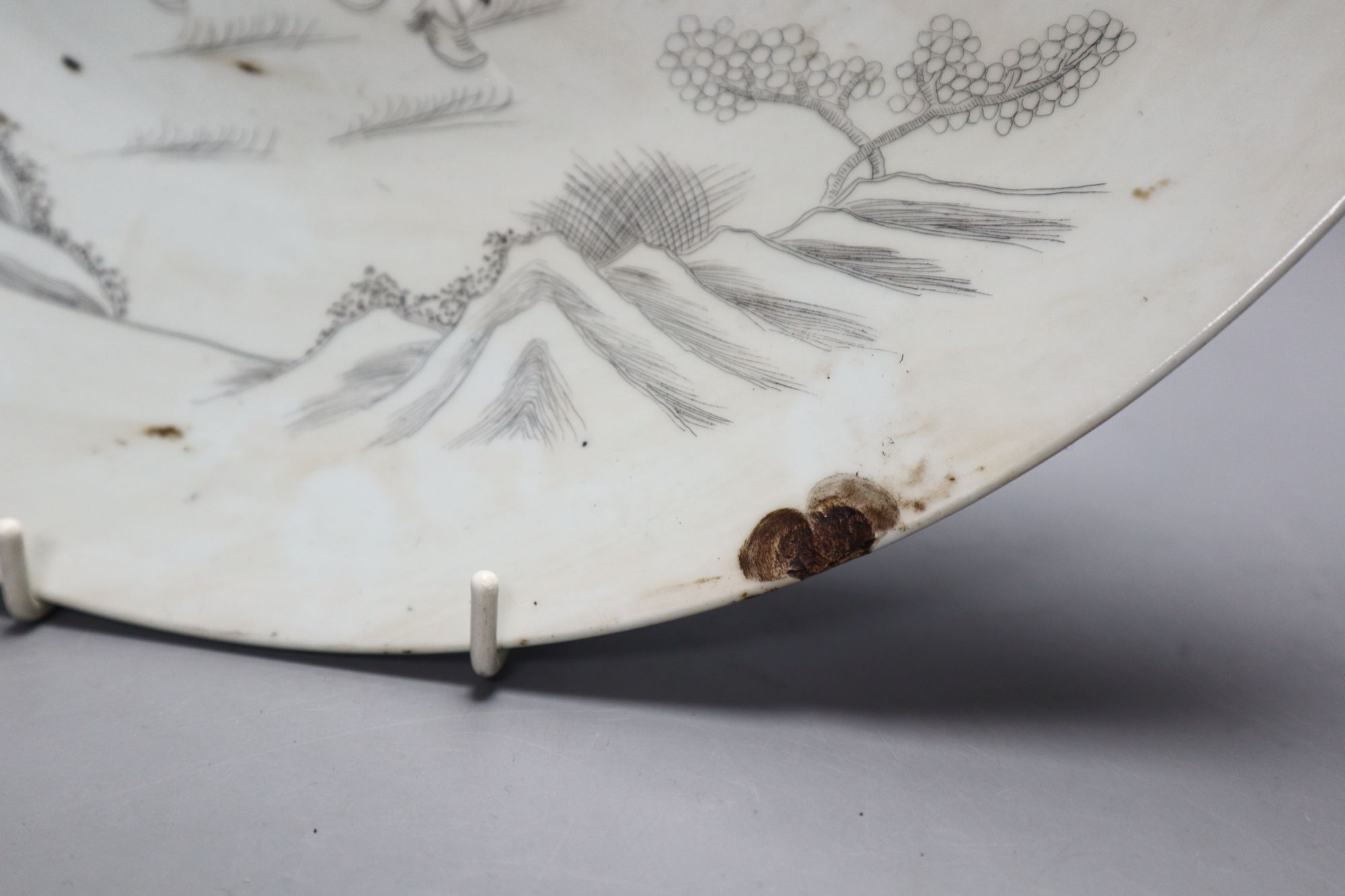 A Chinese porcelain dish engraved with horses, rocks and pine, diameter 33.5cm
